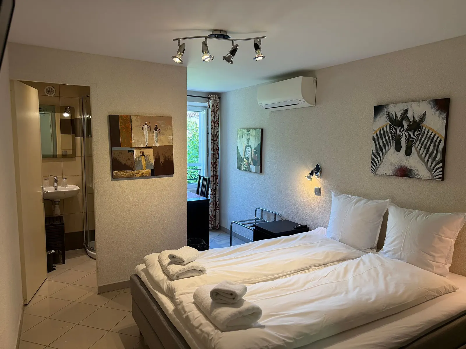 Chambre avec spots au plafond, climatisation et salle de bain attenante