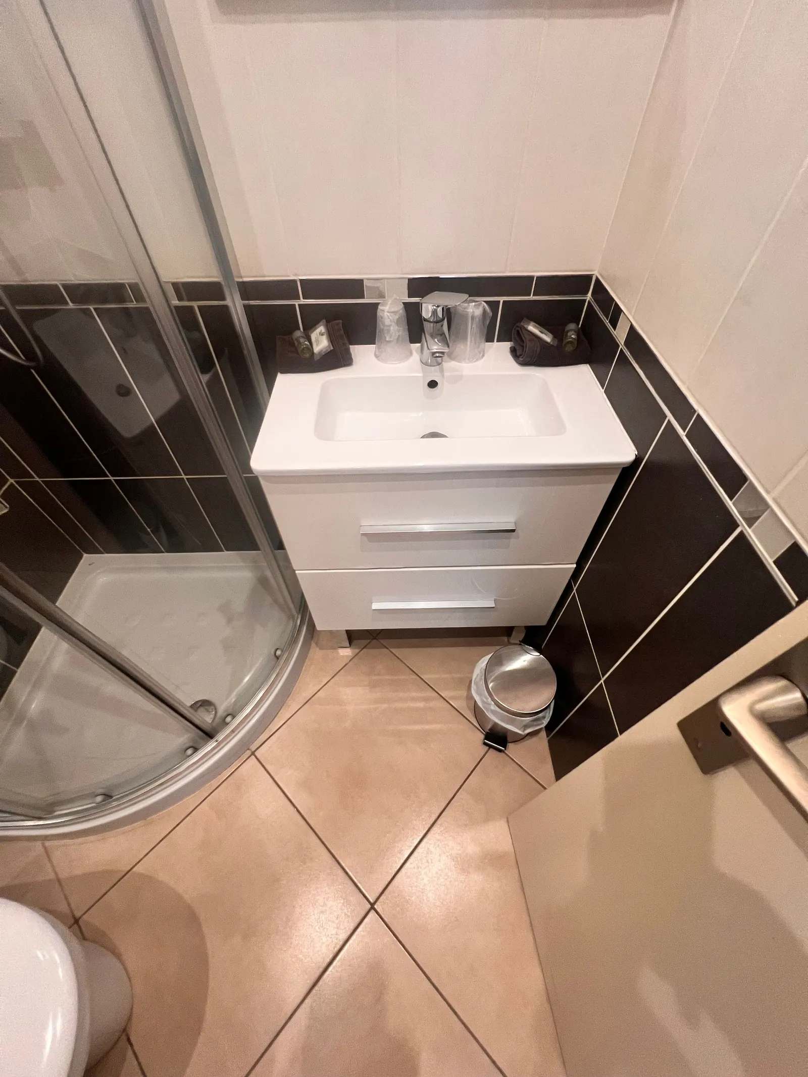 Salle de bain du studio avec lavabo et cabine de douche arrondie