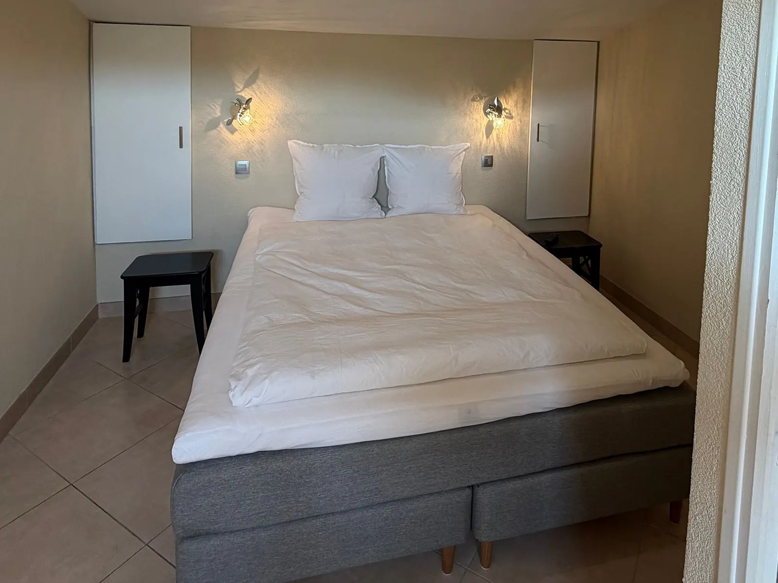 Chambre du studio avec lit double et liseuses de part et d’autre